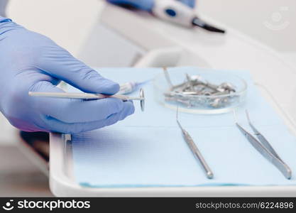 Dental instruments for test the oral cavity and doctor&amp;#39;s hand close up