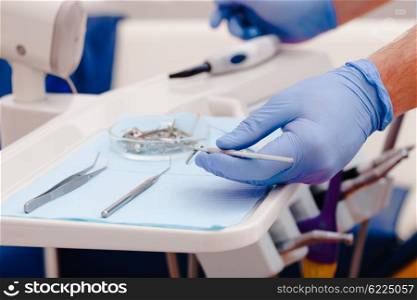 Dental instruments for test the oral cavity and doctor&amp;#39;s hand close up