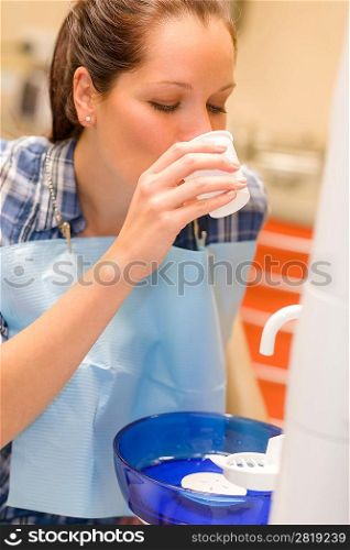 Dental patient woman rinse mouth after teeth check-up