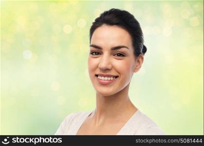 dental, portrait and people concept - happy smiling young woman with braces over green background and lights. happy smiling young woman with braces