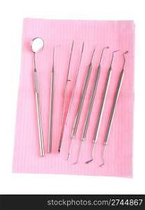 dental surgery instruments on a pink bib (isolated on white background)