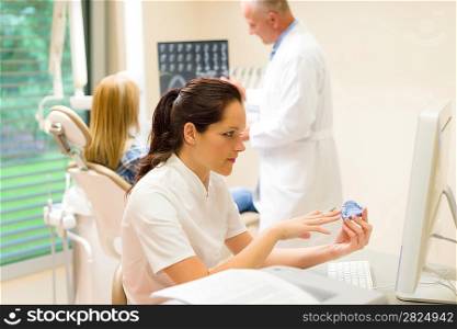 Dental surgery nurse hold print of teeth dentist with patient