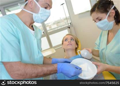 Dentist and assistant mixing paste