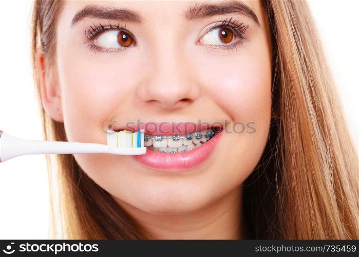 Dentist and orthodontist concept. Young woman cleaning and brushing teeth with blue braces using toothbrush. Woman brushing teeth with braces using brush