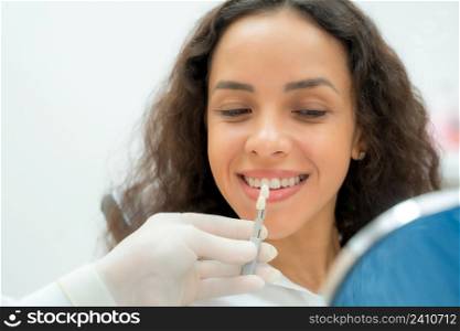 Dentist and patient in dentist office,Doctor compare woman teeth with sampler in dentistry.