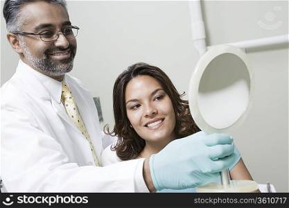 Dentist and patient using mirror