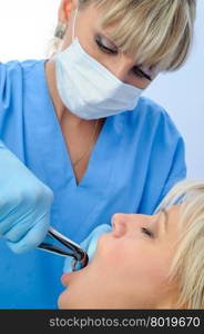 Dentist at work, tooth extraction using forceps