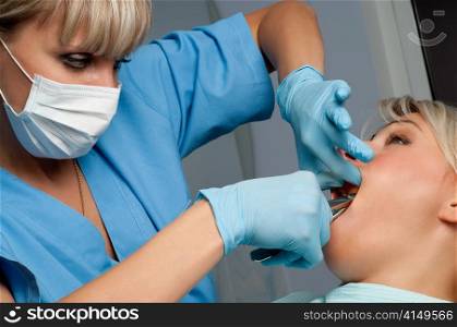 dentist at work, tooth extraction using forceps. tooth extraction