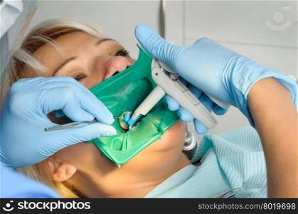 dentist at work with patient, exam, cleaning, curing, using dental water jet