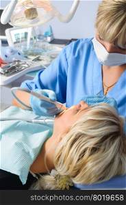dentist at work with patient, expertise, drilling cleaning and curing, using dental water jet