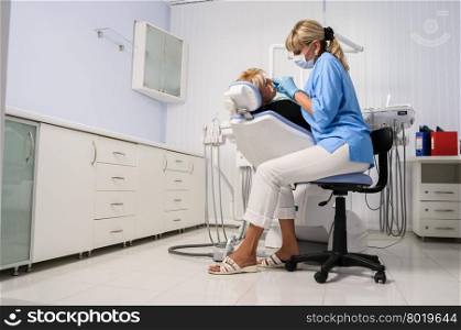 dentist at work with patient in office, dental exam