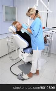dentist at work with patient in office, dental exam