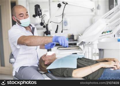dentist checking teeth woman lying dental chair