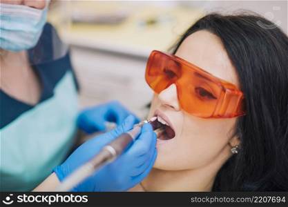 dentist curing teeth patient glasses