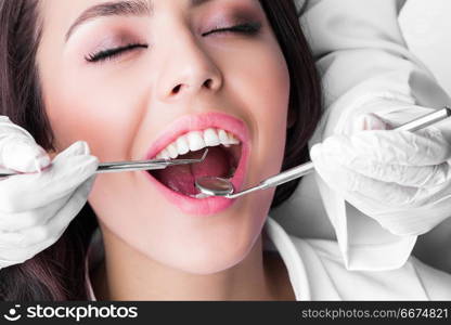 Dentist examines teeth. Dentist examines the teeth of beautiful female patient