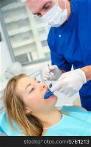 dentist examining his female patients mouth