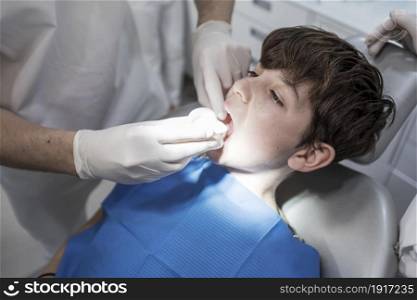 Dentist examining little boy&rsquo;s teeth in clinic. The doctor treats a tooth of little boy at dentist&rsquo;s clinic.