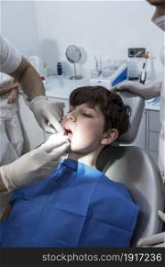 Dentist examining little boy&rsquo;s teeth in clinic. The doctor treats a tooth of little boy at dentist&rsquo;s clinic.