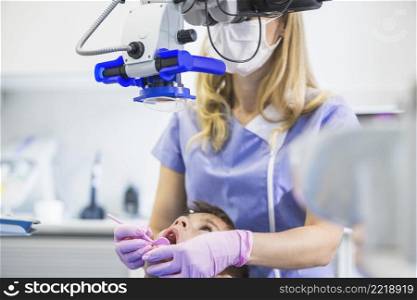 dentist examining patient s teeth through microscope clinic