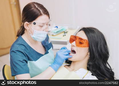 dentist examining teeth patient glasses