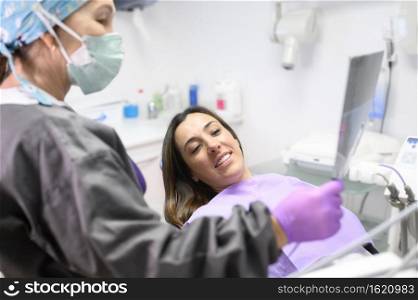 Dentist Explaining The Details Of A X-Ray Picture To Her Patient. High quality photo. Dentist Explaining The Details Of A X-Ray Picture To Her Patient