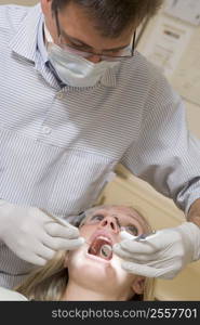 Dentist in exam room with woman in chair