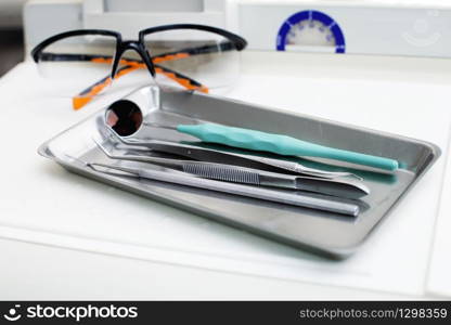 Dentist instruments and protective eyeglasses on the table. Dentist instruments