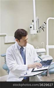 Dentist leafing through medical record