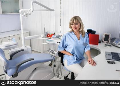 dentist office interior, female doctor sitting at the table