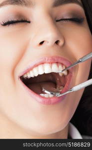 Dentist patient at exam. Close-up of a pretty happy dentist patient with her mouth open at exam