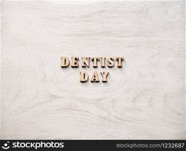 Dentist&rsquo;s day greeting card. White, isolated background, close-up, view from above, wooden surface. Congratulations for relatives, friends and colleagues. Dentist&rsquo;s day greeting card. White background, close up