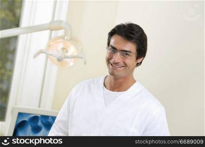 dentist smiling and standing in his office
