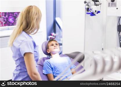 dentist standing near boy sitting dental chair
