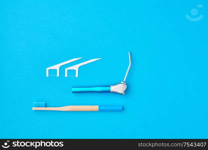 Dentist tools over blue background top view copy space flat lay. Tooth care, dental hygiene and health concept.