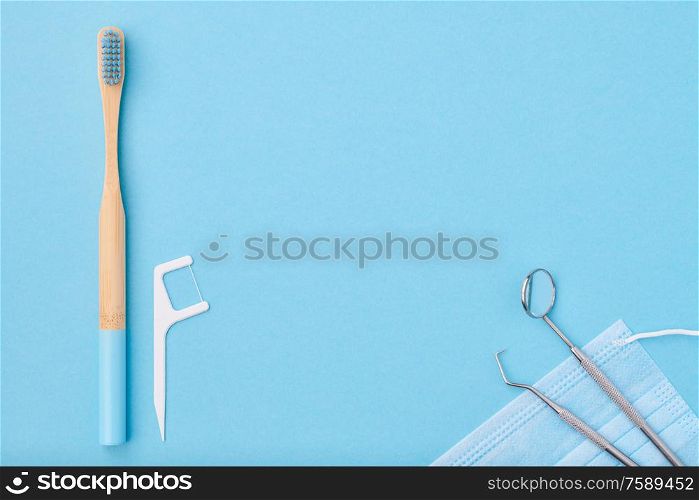 Dentist tools over light blue background top view copy space flat lay. Tooth care, dental hygiene and health concept.