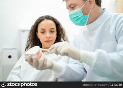 Dentist with gloves showing on a jaw model how to clean the teeth with toothbrush properly and right,Medicine,Teeth health concept.