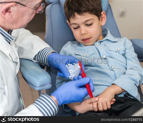 Dentist with little boy, talking about dental hygiene