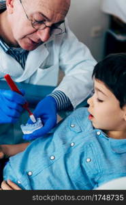 Dentist with little boy, talking about dental hygiene