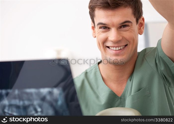 Dentist with xray in hand, smiling at the camera