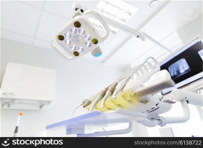 dentistry, medicine, medical equipment and stomatology concept - close up of lamp and dental unit instruments clinic office