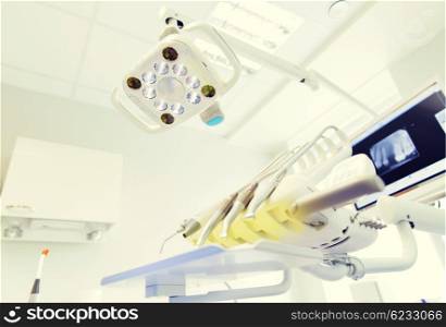 dentistry, medicine, medical equipment and stomatology concept - close up of lamp and dental unit instruments clinic office