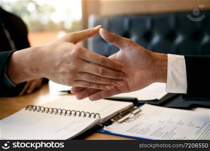 Department heads manager are shaking hands and accept to new employee in office room.