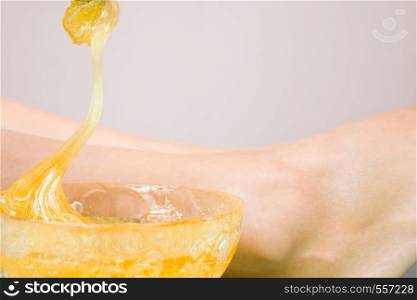 depilation and beauty concept - procedure of hair removing on leg beautiful woman with sugar paste or wax honey. procedure of hair removing on leg beautiful woman with sugar paste or wax honey - depilation and beauty concept