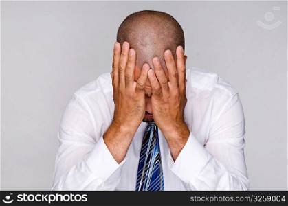 Depressed businessman holding head with hands.
