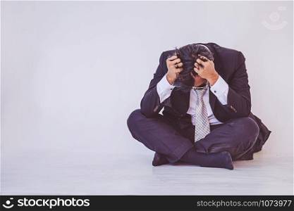 Depressed businessman sitting on the floor