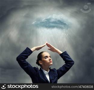 Depressed businesswoman. Young crying businesswoman with arms covering head from rain