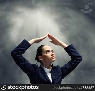 Depressed businesswoman. Young crying businesswoman with arms covering head from rain