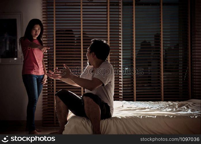 depressed Couple Husband and wife are quarreling on the bed in the dark bedroom with low light environment, dramatic concept