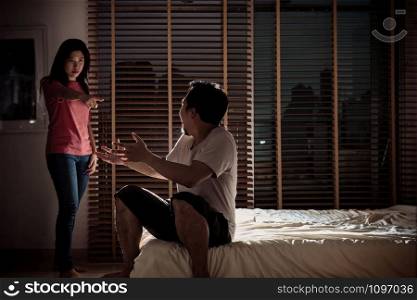 depressed Couple Husband and wife are quarreling on the bed in the dark bedroom with low light environment, dramatic concept