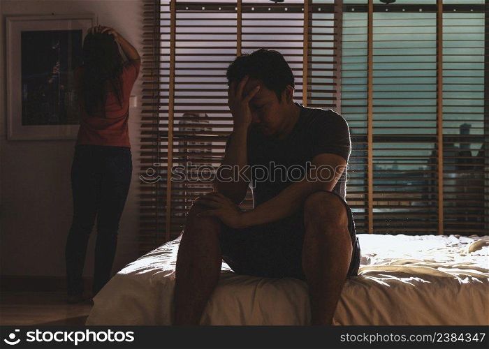 depressed Couple Husband and wife sitting head in hands on the bed in the dark bedroom with low light environment, dramatic concept